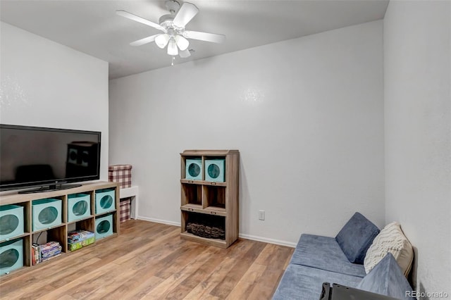 living room featuring wood finished floors, ceiling fan, and baseboards