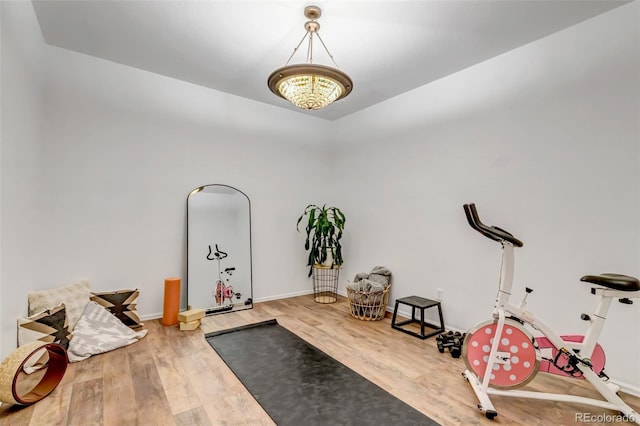 exercise area with wood finished floors and baseboards