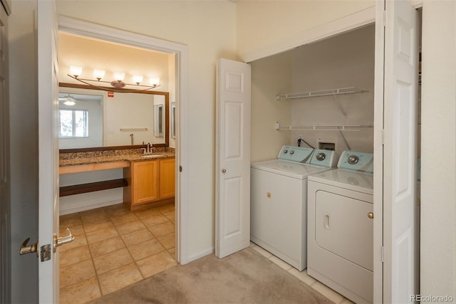 laundry area with ceiling fan, light tile patterned floors, washer and clothes dryer, and sink