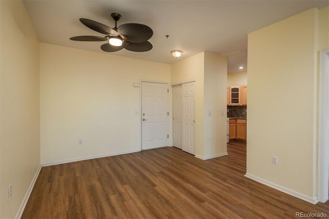 spare room featuring ceiling fan, baseboards, and wood finished floors