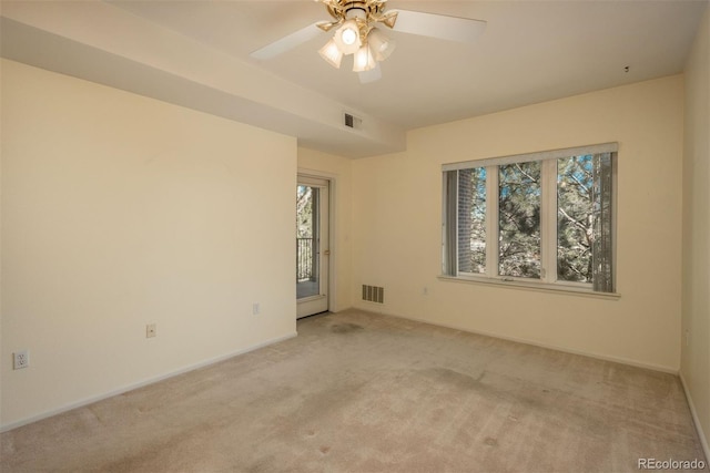 empty room with visible vents, light carpet, baseboards, and ceiling fan