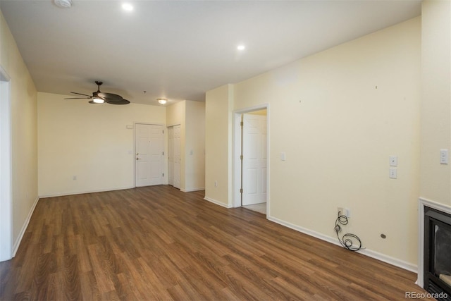 unfurnished living room with ceiling fan, baseboards, and wood finished floors