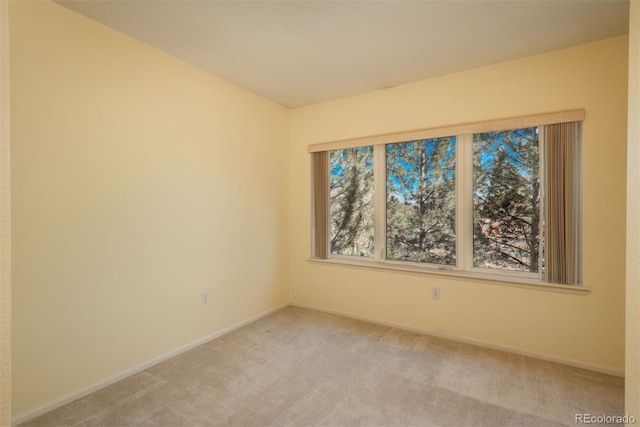 spare room with light carpet and baseboards