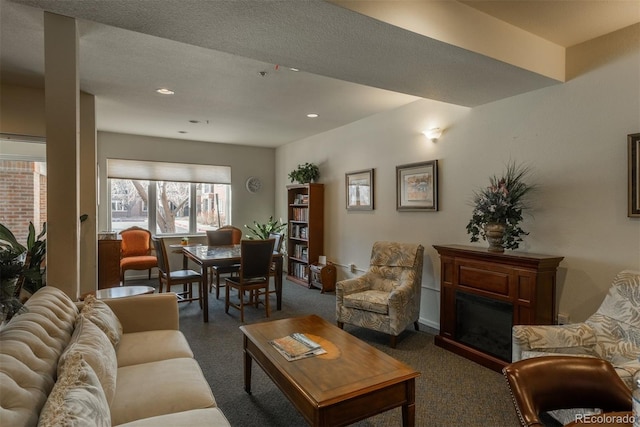 living room with recessed lighting, a textured ceiling, and a fireplace