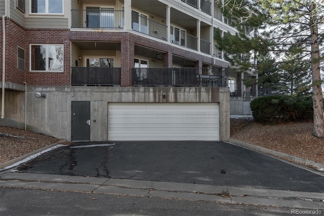 2896 W Riverwalk Cir Unit 204, Littleton, CO 80123 - view of front of house featuring brick siding, an attached garage, and driveway