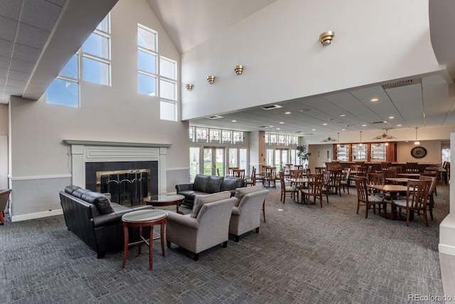 2896 W Riverwalk Cir Unit 204, Littleton, CO 80123 - living area featuring dark colored carpet, a high ceiling, a tiled fireplace, and recessed lighting