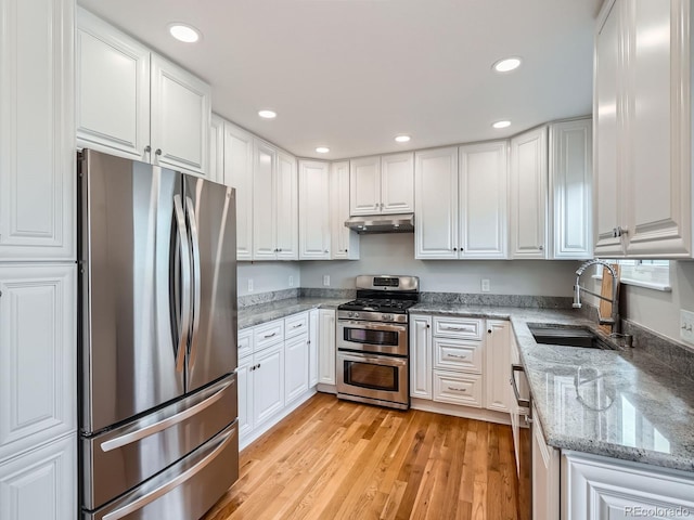 kitchen featuring dark stone countertops, sink, white cabinets, and appliances with stainless steel finishes