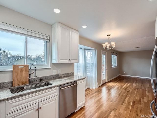 kitchen featuring white cabinetry, dishwasher, sink, hanging light fixtures, and light stone countertops