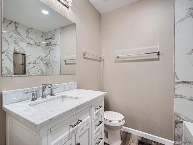 bathroom with walk in shower, vanity, toilet, and hardwood / wood-style floors