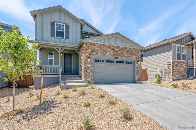 craftsman-style house featuring a garage, covered porch, board and batten siding, and driveway