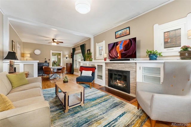 1215 Jackson St, Denver, CO 80206 - living area with a stone fireplace, wood finished floors, ornamental molding, and a ceiling fan