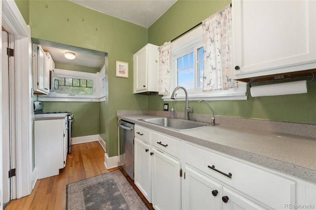 1215 Jackson St, Denver, CO 80206 - kitchen featuring appliances with stainless steel finishes, white cabinetry, light wood-style floors, light countertops, and plenty of natural light