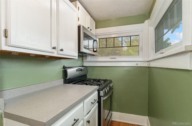 1215 Jackson St, Denver, CO 80206 - kitchen with stainless steel appliances, white cabinets, and light countertops