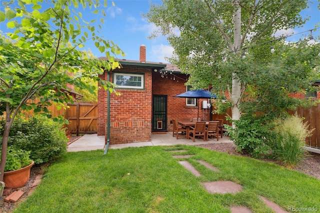 1215 Jackson St, Denver, CO 80206 - rear view of property with a chimney, brick siding, and a patio area