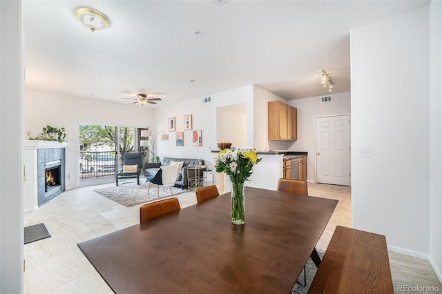 4451 S Ammons St Unit 4-108, Littleton, CO 80123 - dining area featuring a tiled fireplace and a ceiling fan