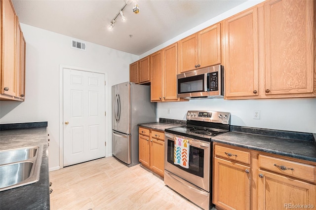 4451 S Ammons St Unit 4-108, Littleton, CO 80123 - kitchen with stainless steel appliances, dark countertops, track lighting, and a sink