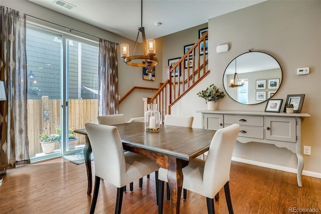 dining area with a healthy amount of sunlight, a chandelier, and light hardwood / wood-style flooring