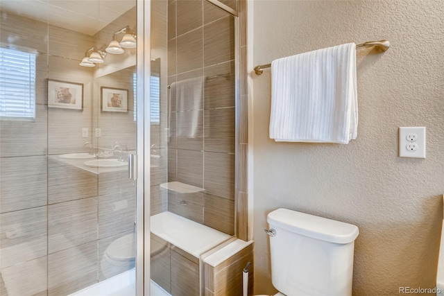 bathroom featuring toilet and a shower with door