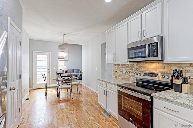 14214 Lakeview Ln, Broomfield, CO 80023 - kitchen featuring appliances with stainless steel finishes, decorative backsplash, white cabinetry, light wood finished floors, and baseboards