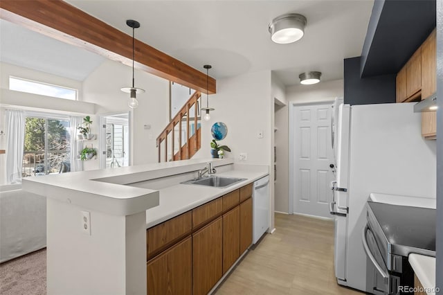 kitchen with white appliances, beamed ceiling, hanging light fixtures, light countertops, and a sink