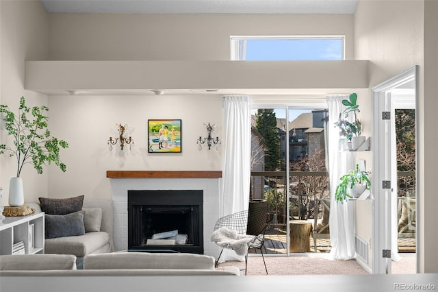 carpeted living room featuring a fireplace and visible vents