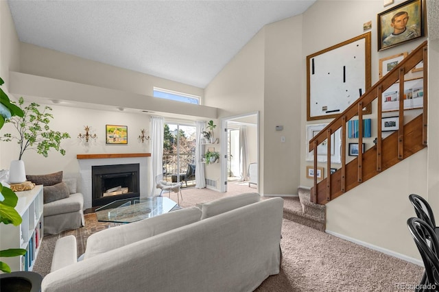 carpeted living room with baseboards, stairway, a textured ceiling, a brick fireplace, and high vaulted ceiling