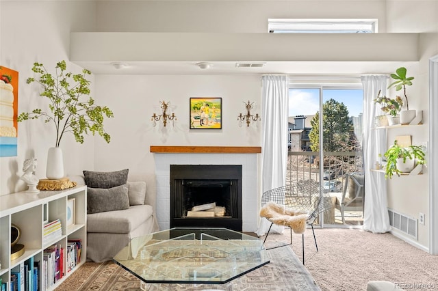 sitting room featuring carpet, a fireplace, and visible vents