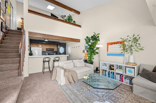 carpeted living area featuring a high ceiling, stairway, and beamed ceiling