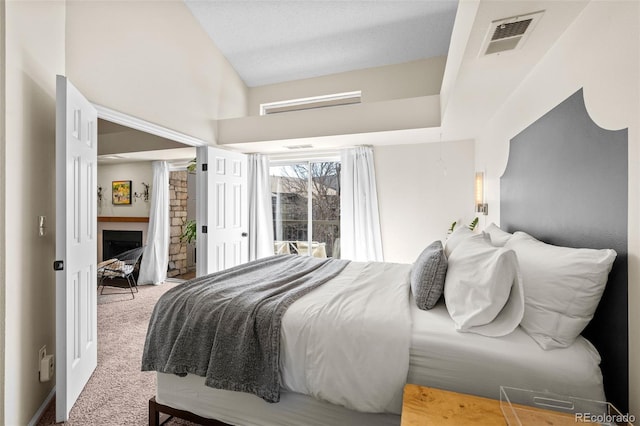 carpeted bedroom with visible vents and a fireplace