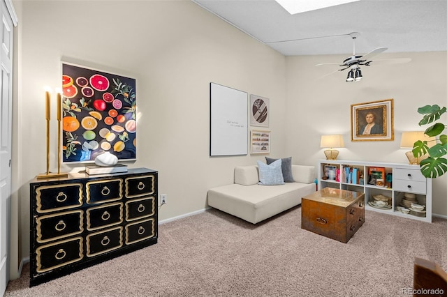 living area with lofted ceiling with skylight, carpet, a ceiling fan, and baseboards