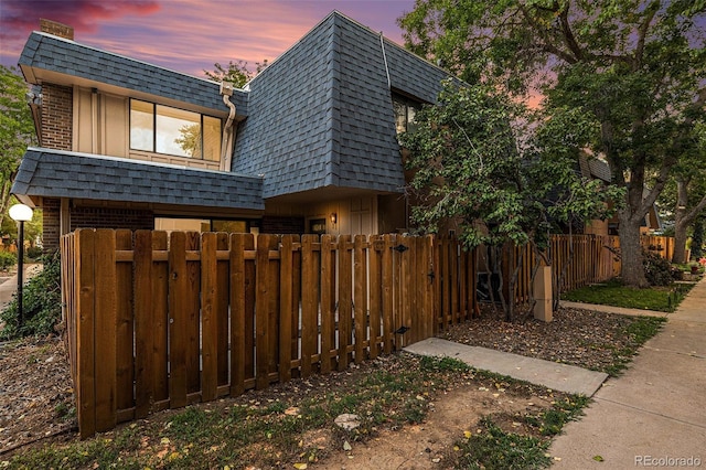 yard at dusk with a fenced front yard