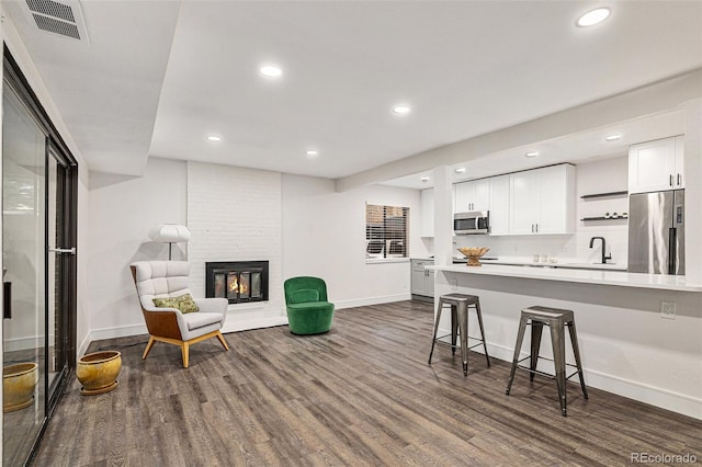 interior space with visible vents, white cabinets, a breakfast bar, stainless steel appliances, and light countertops