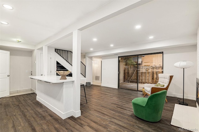 sitting room with dark wood-type flooring, stairway, visible vents, and recessed lighting