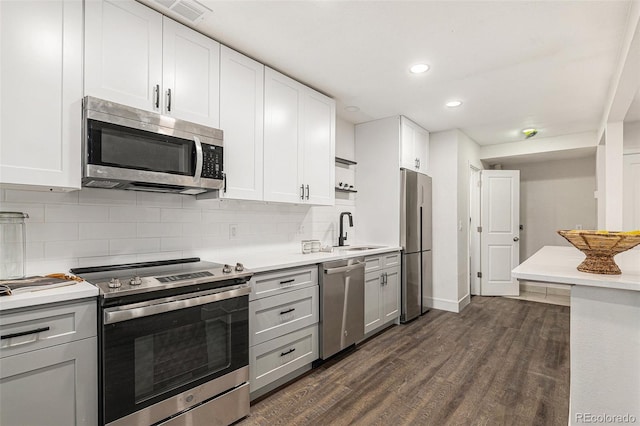 kitchen featuring a sink, white cabinets, stainless steel appliances, and light countertops