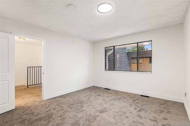 unfurnished room featuring carpet flooring, a textured ceiling, and baseboards