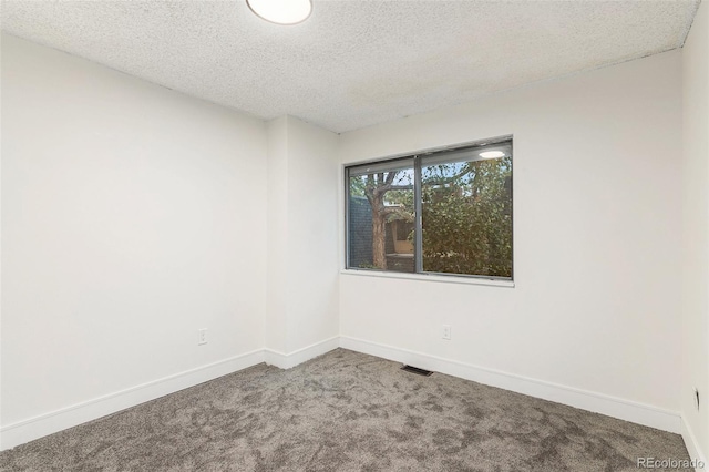 spare room with baseboards, a textured ceiling, visible vents, and carpet flooring