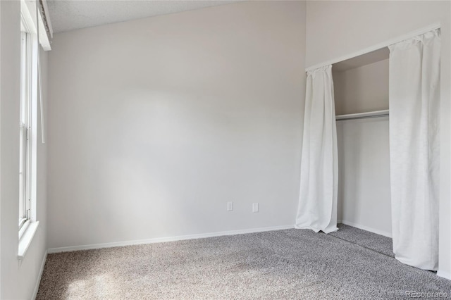 unfurnished bedroom with a closet, baseboards, and carpet flooring