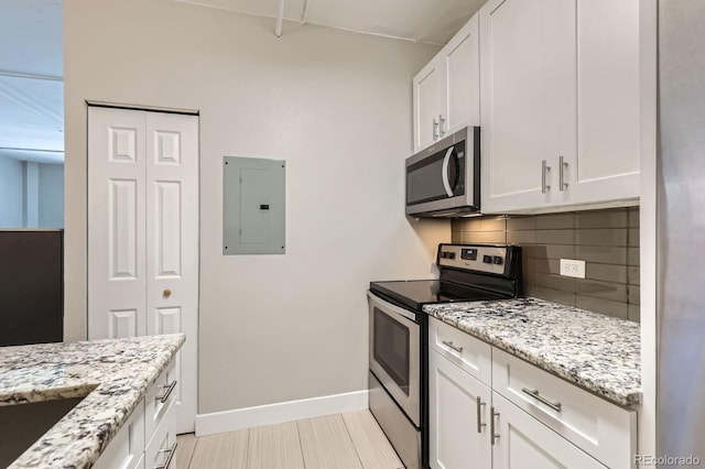 444 17th St Unit 701, Denver, CO 80202 - kitchen featuring appliances with stainless steel finishes, electric panel, baseboards, tasteful backsplash, and white cabinets