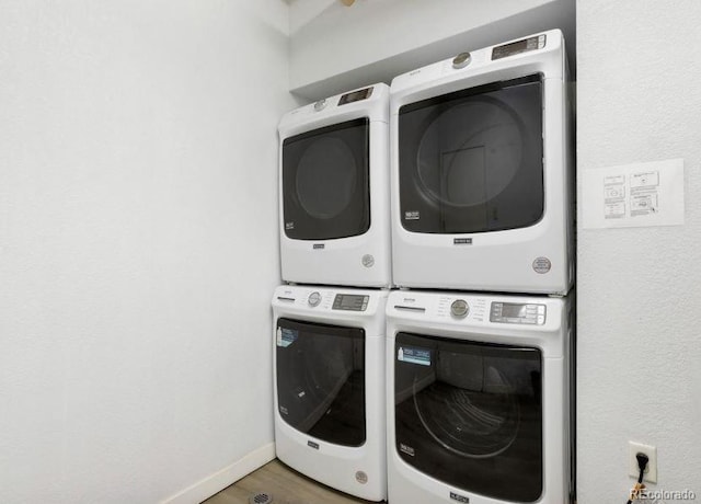 444 17th St Unit 701, Denver, CO 80202 - laundry room featuring stacked washer / dryer, wood finished floors, and baseboards