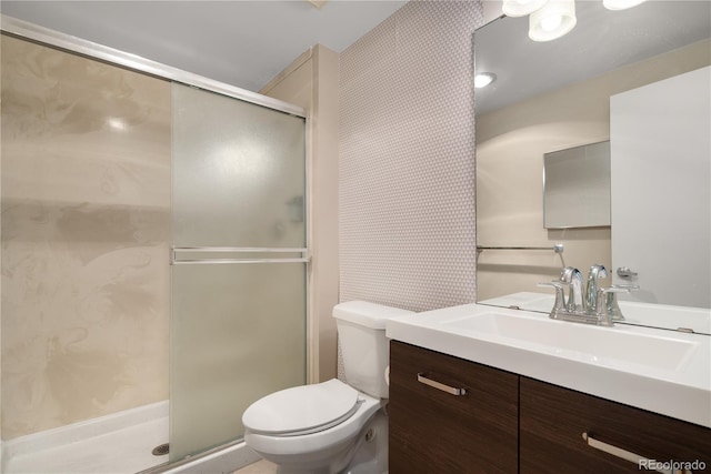 bathroom featuring vanity, an enclosed shower, and toilet