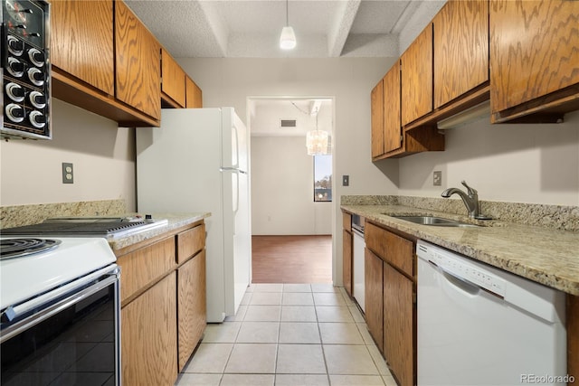 kitchen with decorative light fixtures, sink, light tile patterned floors, white appliances, and a textured ceiling