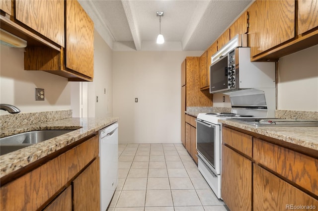 kitchen featuring sink, hanging light fixtures, a textured ceiling, light tile patterned floors, and white appliances