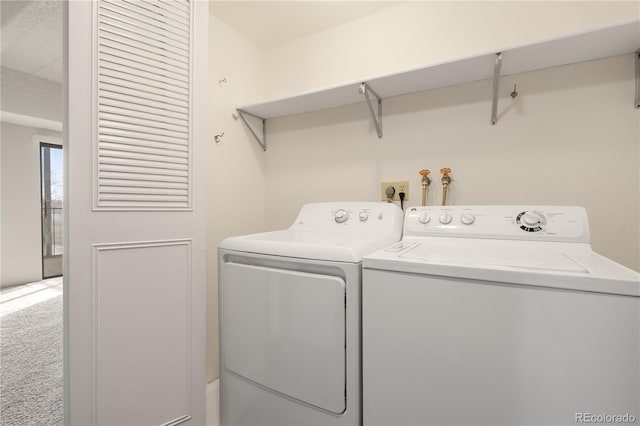 laundry area featuring washing machine and dryer and carpet