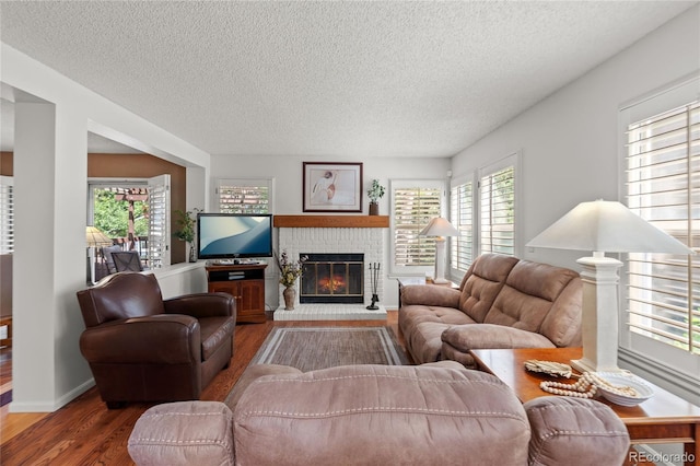 2181 E Phillips Ln, Centennial, CO 80122 - living area featuring a textured ceiling, wood finished floors, and a brick fireplace
