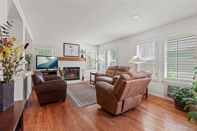 2181 E Phillips Ln, Centennial, CO 80122 - living area with a textured ceiling, wood finished floors, healthy amount of natural light, and a brick fireplace