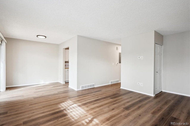 unfurnished room with dark hardwood / wood-style floors and a textured ceiling