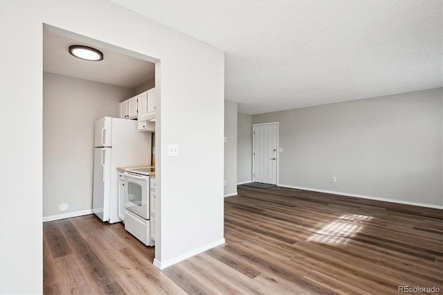 kitchen with electric stove, dark hardwood / wood-style flooring, a textured ceiling, and white cabinets