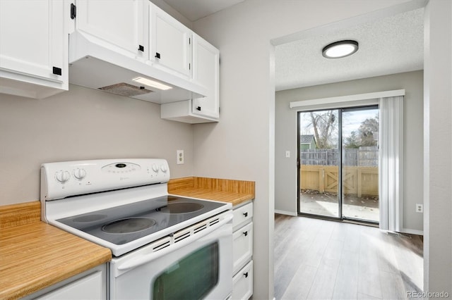 kitchen with white electric range oven, a textured ceiling, light hardwood / wood-style flooring, and white cabinets