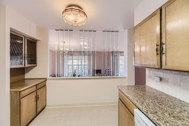 kitchen with light tile patterned flooring, backsplash, and an inviting chandelier