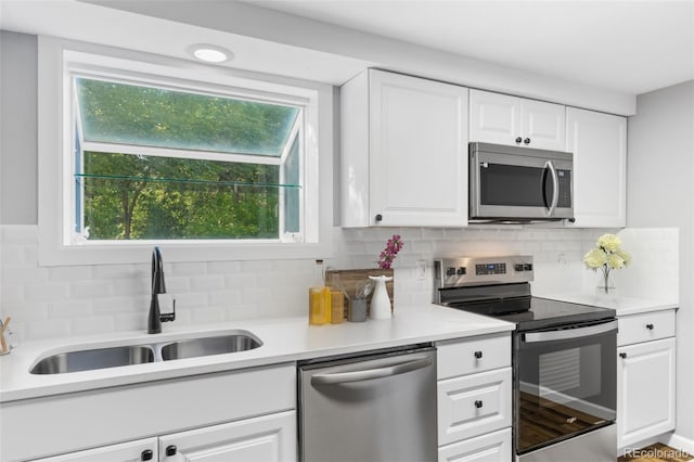 kitchen featuring backsplash, white cabinetry, sink, and stainless steel appliances